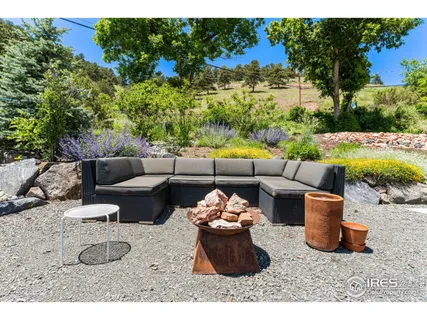 a view of a backyard with furniture and garden