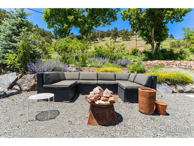 a view of a backyard with furniture and garden