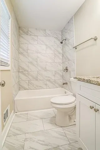 a bathroom with a toilet and a bath tub