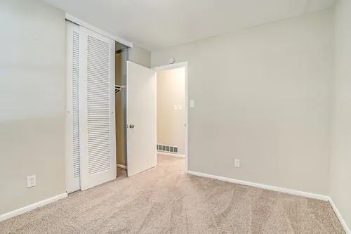 an empty room with closet and a bathroom