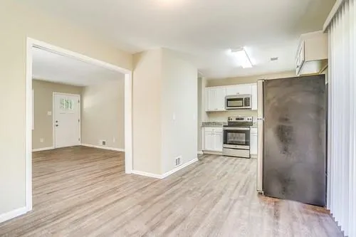 a view of a kitchen with wooden floor and a refrigerator