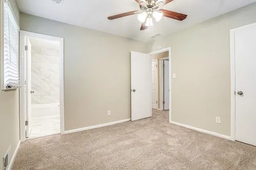 an empty room with closet and a chandelier fan