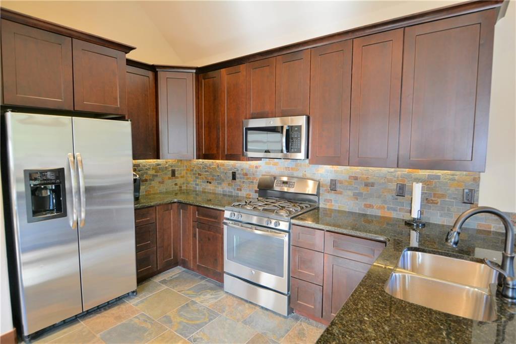 878 Independence Road, Unit 1A Keystone, CO 80435 - Photo 17 of 25 a kitchen with stainless steel appliances granite countertop a refrigerator sink and stove