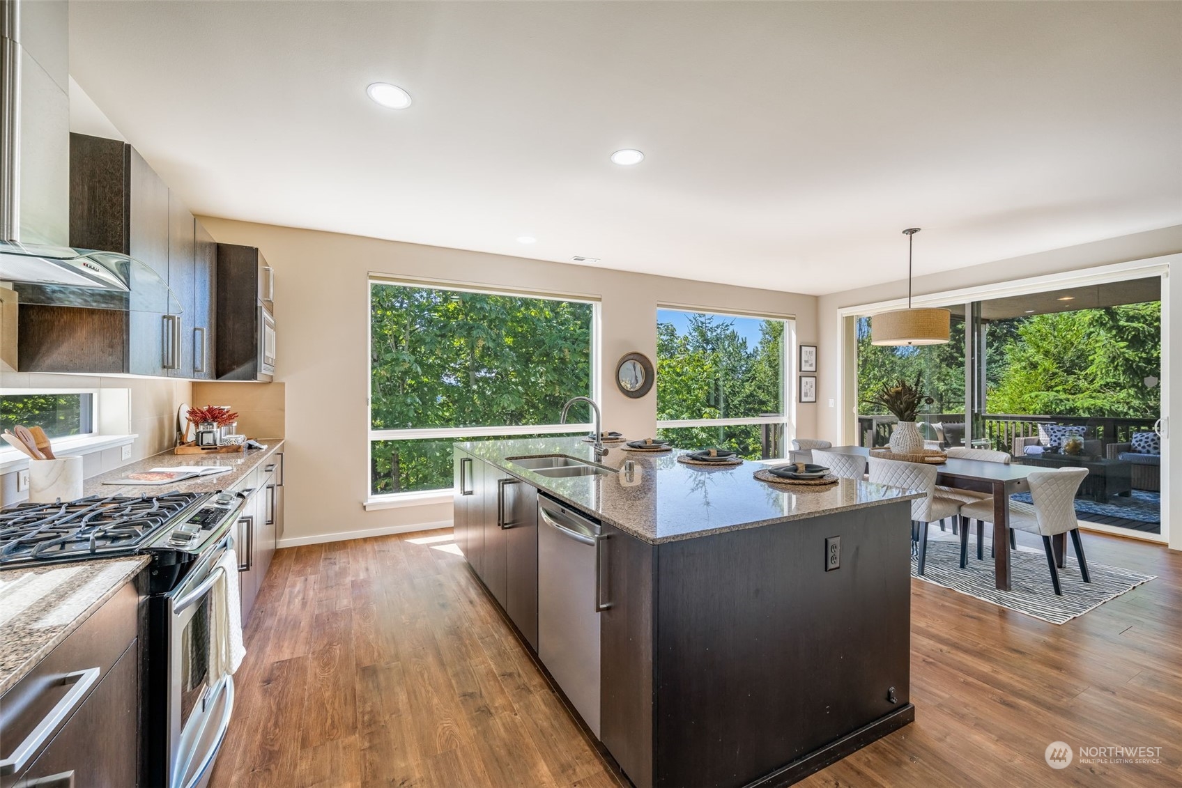 10014 Southeast 192nd Place Renton, WA 98055 - Photo 11 of 35 a kitchen with a stove a sink a kitchen island dining table and chairs