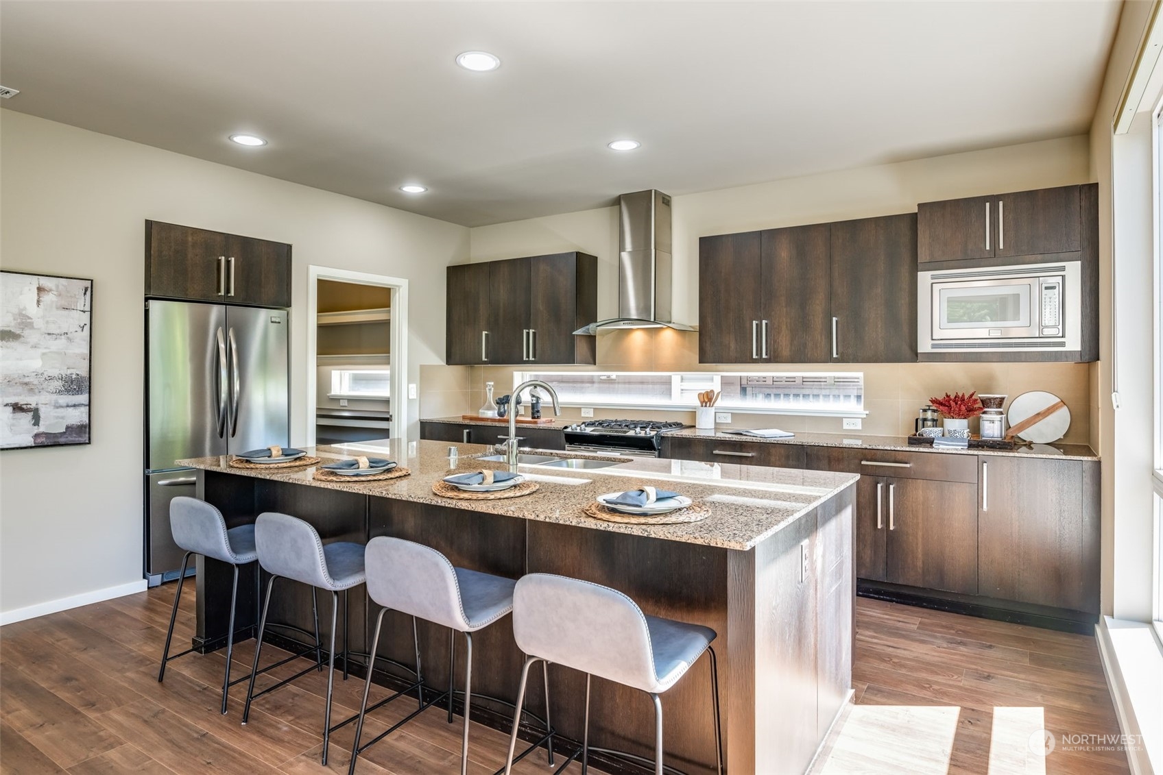 10014 Southeast 192nd Place Renton, WA 98055 - Photo 10 of 35 a kitchen with stainless steel appliances granite countertop a stove a sink a refrigerator white cabinets and chairs