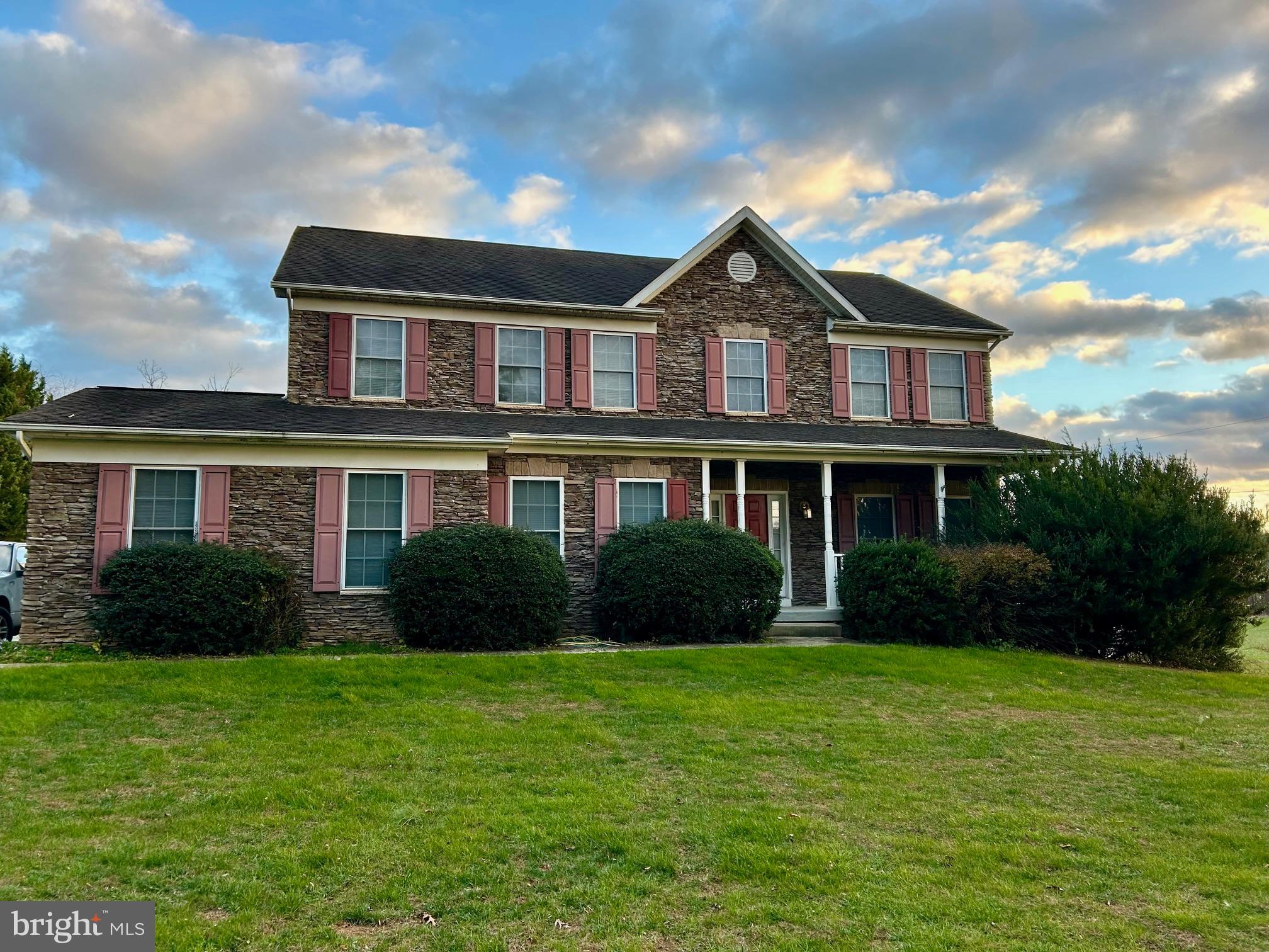 a front view of a house with garden and porch