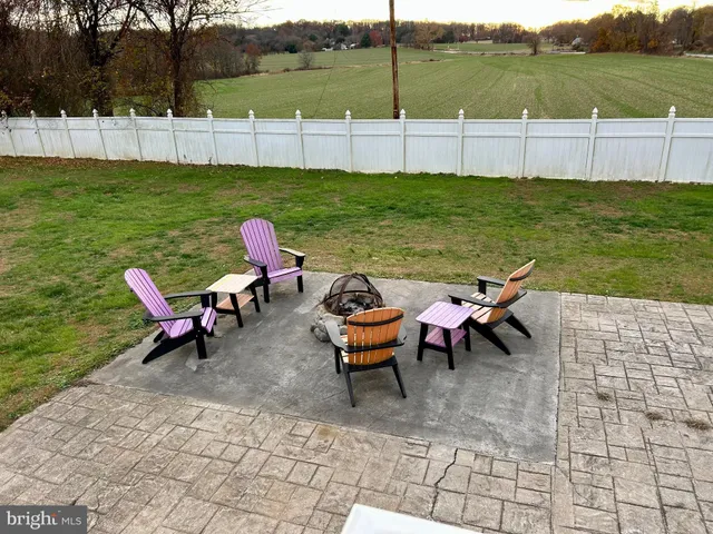 a view of a patio with table and chairs with wooden floor and fence