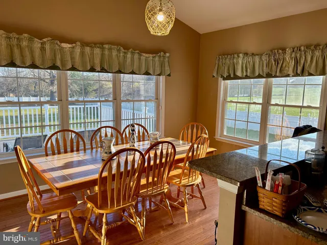 a view of a dining room with furniture a chandelier and a window
