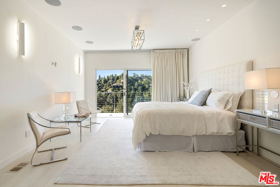 9422 Readcrest Drive Beverly Hills, CA 90210 - Photo 17 of 34 a spacious bedroom with a bed and a window