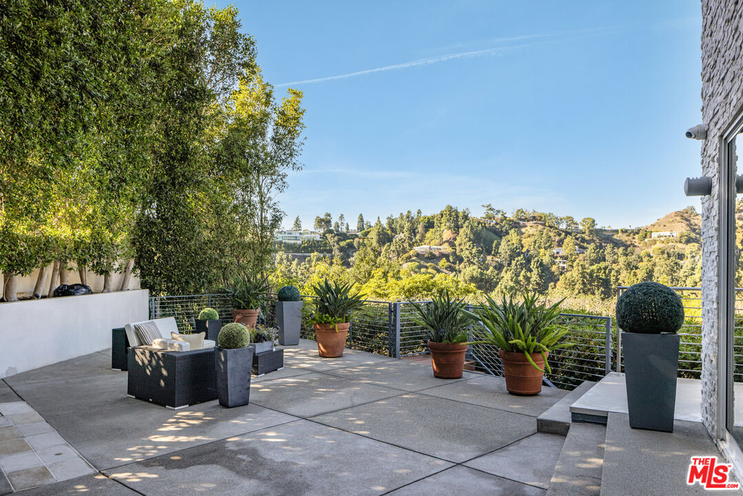 9422 Readcrest Drive Beverly Hills, CA 90210 - Photo 29 of 34 a backyard of a house with glass top table and chairs