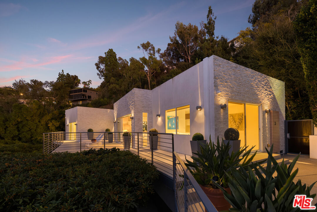 9422 Readcrest Drive Beverly Hills, CA 90210 - Photo 4 of 34 a view of a house with many windows and a yard