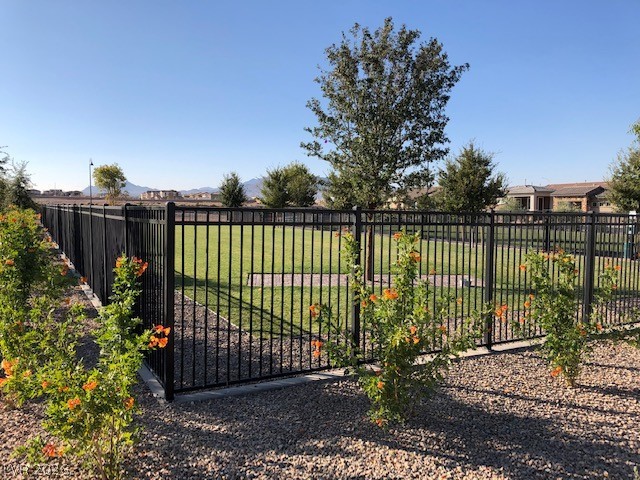498 Pebble Run Avenue Henderson, NV 89011 - Photo 46 of 47 A well-maintained community park area is enclosed by a secure black fence.