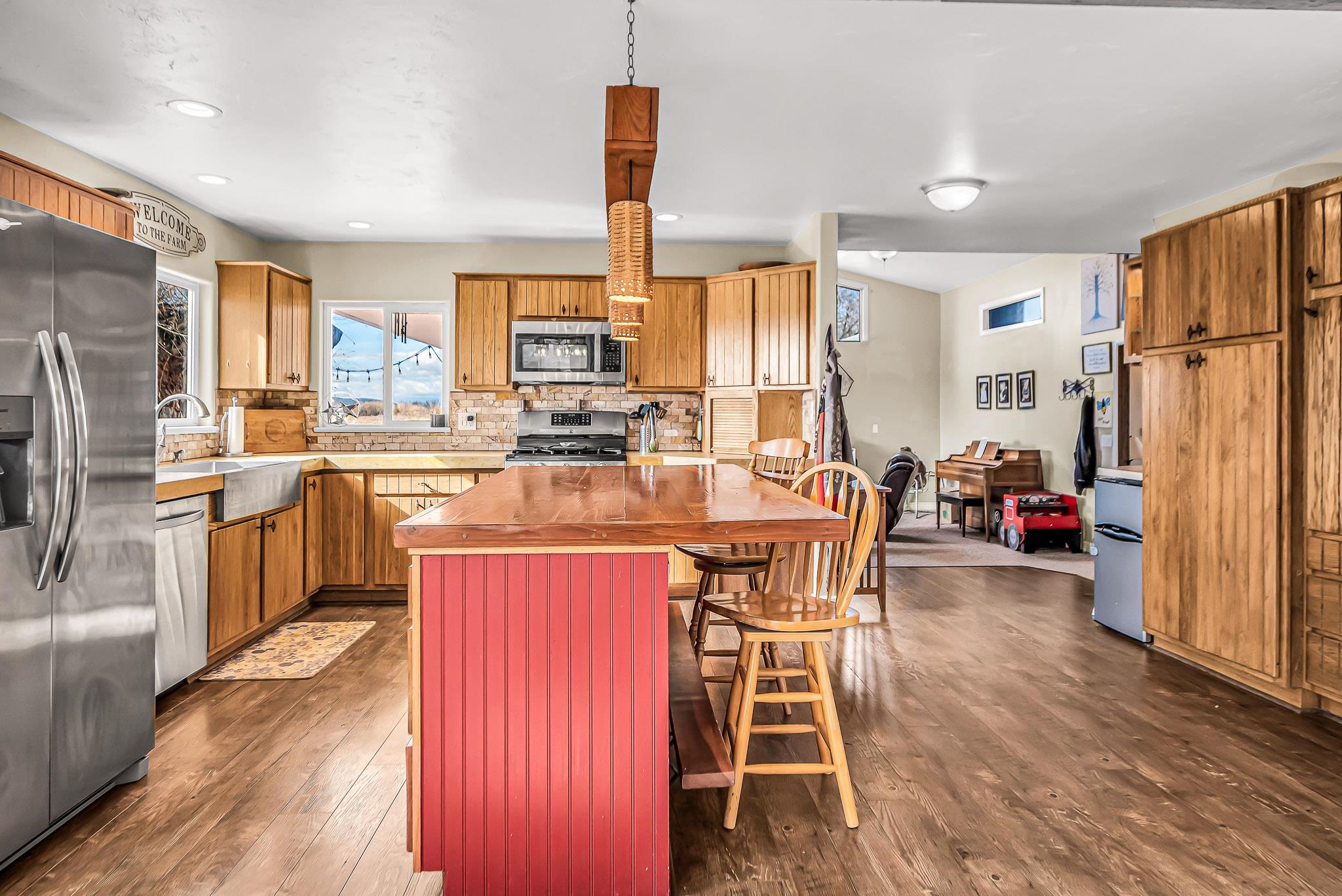 1473 19 Road Fruita, CO 81521 - Photo 7 of 41 a kitchen with stainless steel appliances a refrigerator a stove a sink dishwasher a dining table and chairs with wooden floor