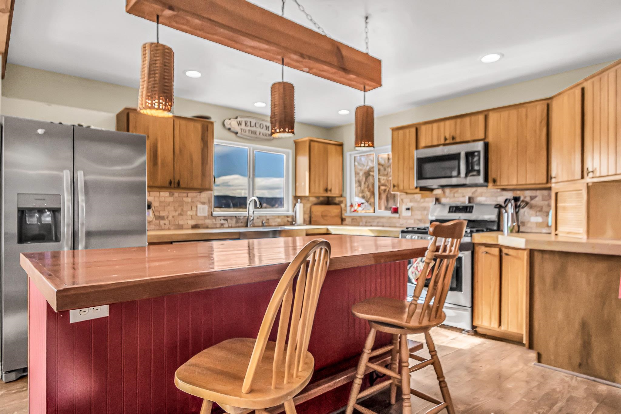 1473 19 Road Fruita, CO 81521 - Photo 8 of 41 a dining room with stainless steel appliances kitchen island granite countertop a table chairs and a refrigerator