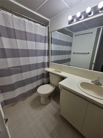 a bathroom with a sink a toilet a mirror and shower