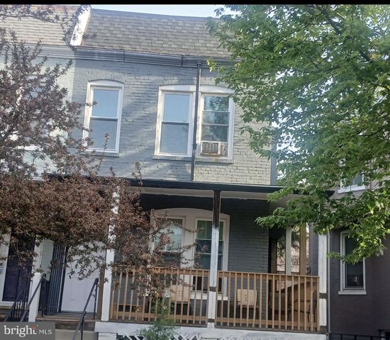a front view of a house with a tree