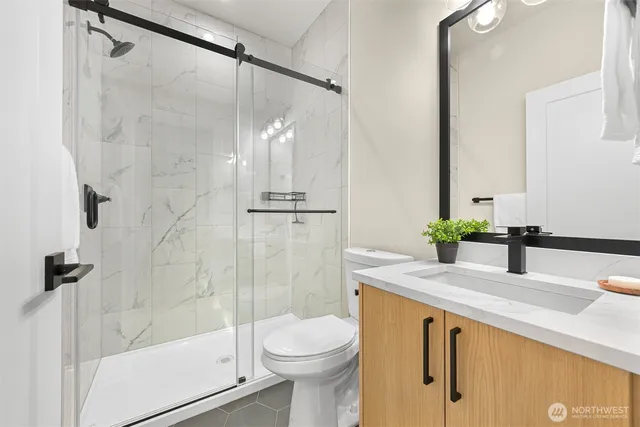 a bathroom with a granite countertop sink toilet and shower