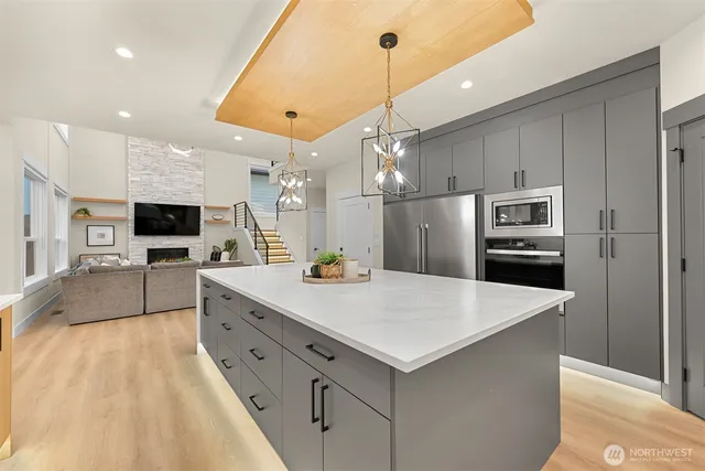 a large kitchen with stainless steel appliances kitchen island granite countertop a refrigerator and a sink