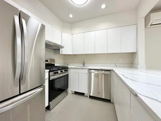 a kitchen with stainless steel appliances granite countertop a refrigerator sink and stove