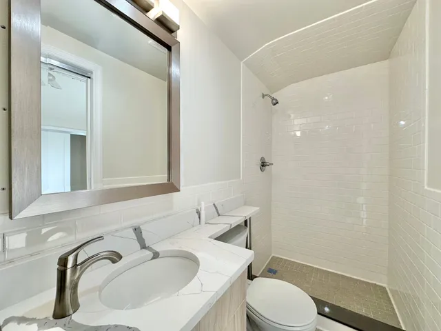 a bathroom with a sink toilet and a mirror