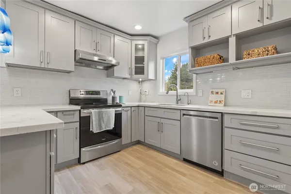 a kitchen with stainless steel appliances granite countertop a sink a stove and a refrigerator