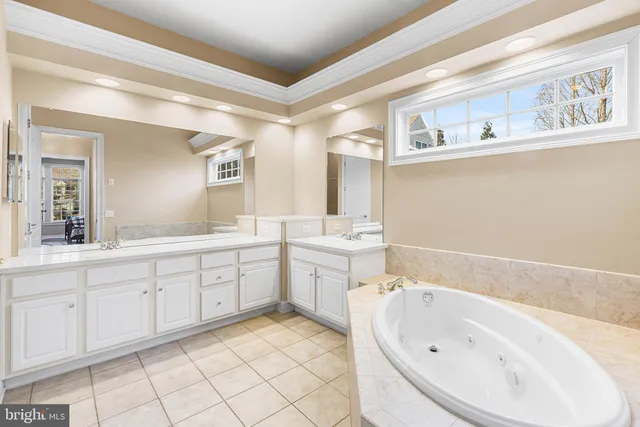 a spacious bathroom with a tub sink and mirror