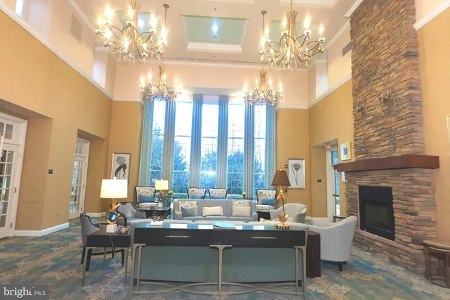 a view of a dining room with furniture a chandelier and large windows