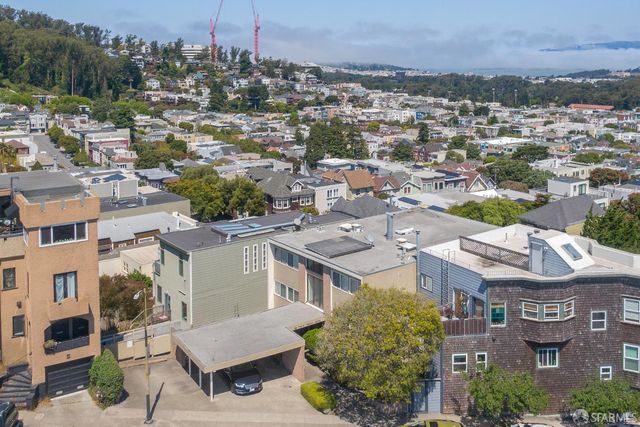 an aerial view of residential houses with outdoor space and trees