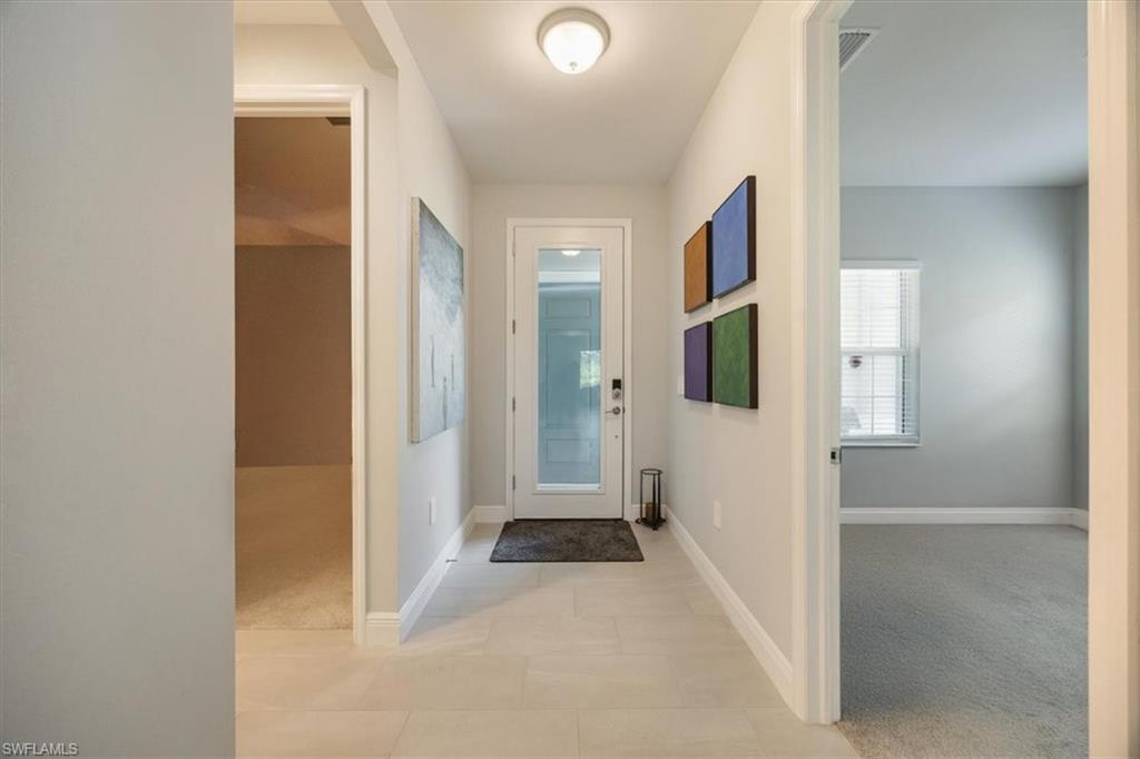 2401 Ariane Drive Naples, FL 34112 - Photo 5 of 17 a view of a hallway with wooden floor and livingroom