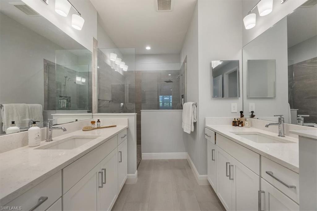 2401 Ariane Drive Naples, FL 34112 - Photo 7 of 17 a spacious bathroom with a double vanity sink mirror and double