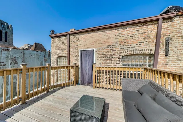 a patio with a table and chairs and potted plants