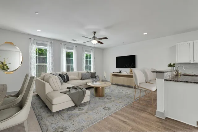 a living room with furniture a flat screen tv and a large window