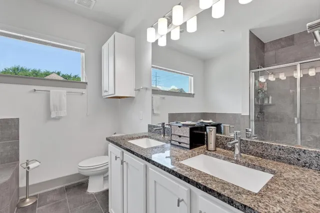 a bathroom with a granite countertop sink a toilet and a mirror