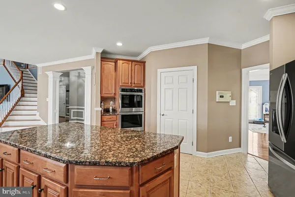 a kitchen with granite countertop a stove top oven a sink a counter space and cabinets