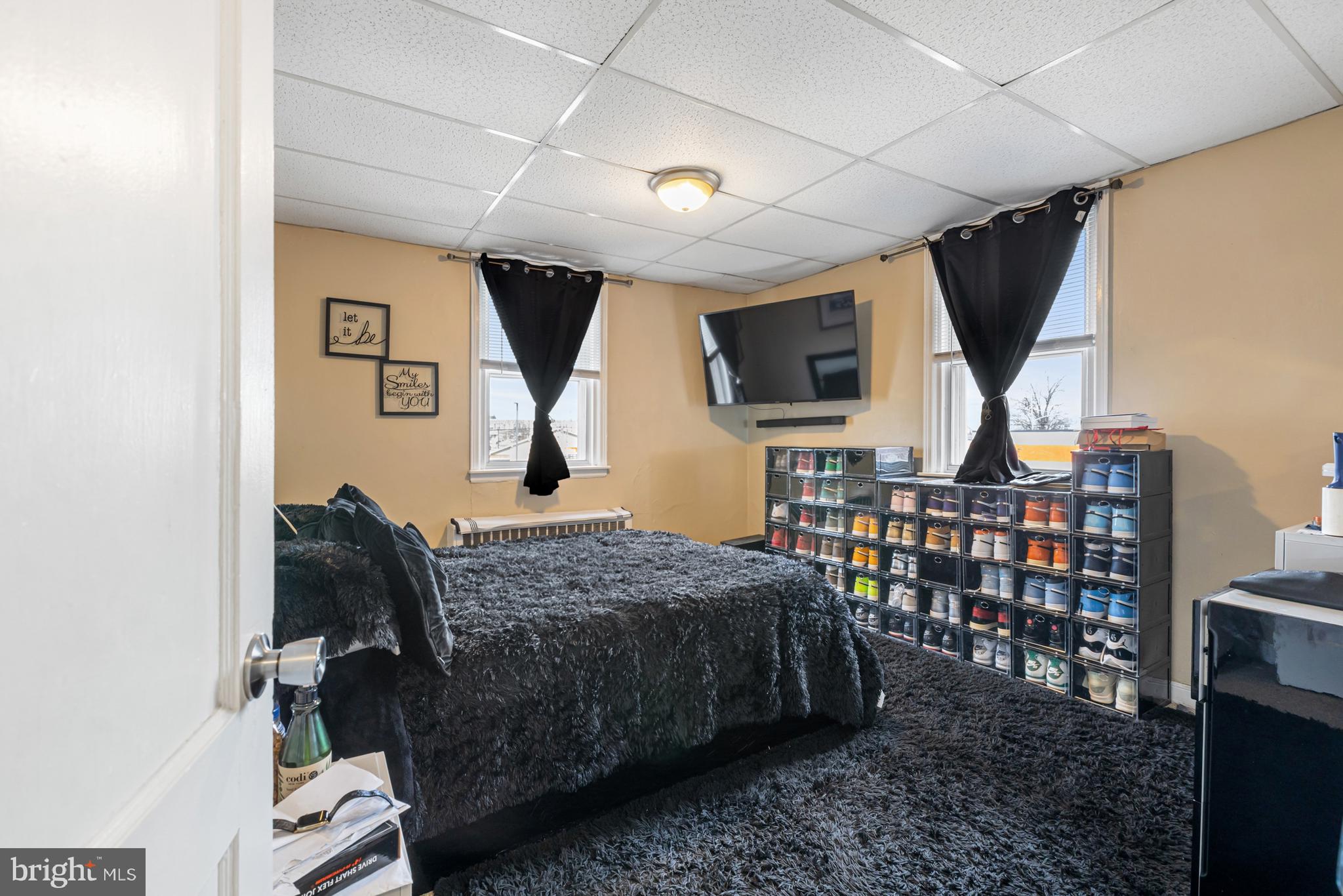 6136 Hawthorne Street Philadelphia, PA 19135 - Photo 24 of 38 a bedroom with a bed a flat tv screen and a bookshelf
