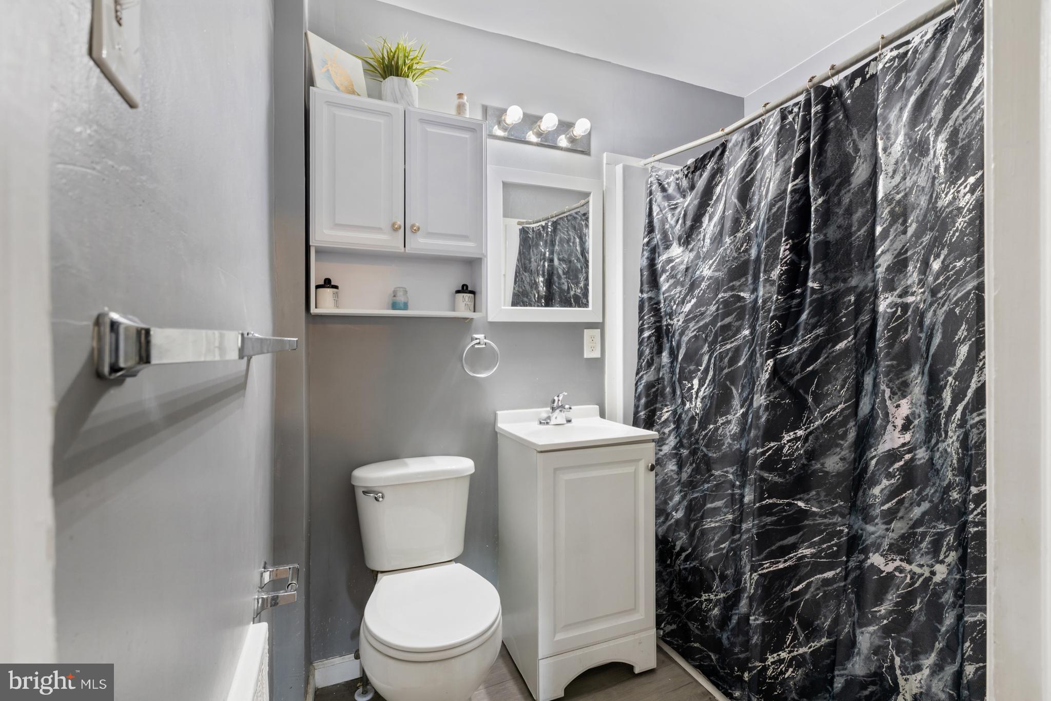 6136 Hawthorne Street Philadelphia, PA 19135 - Photo 26 of 38 a bathroom with a toilet and a shower curtain