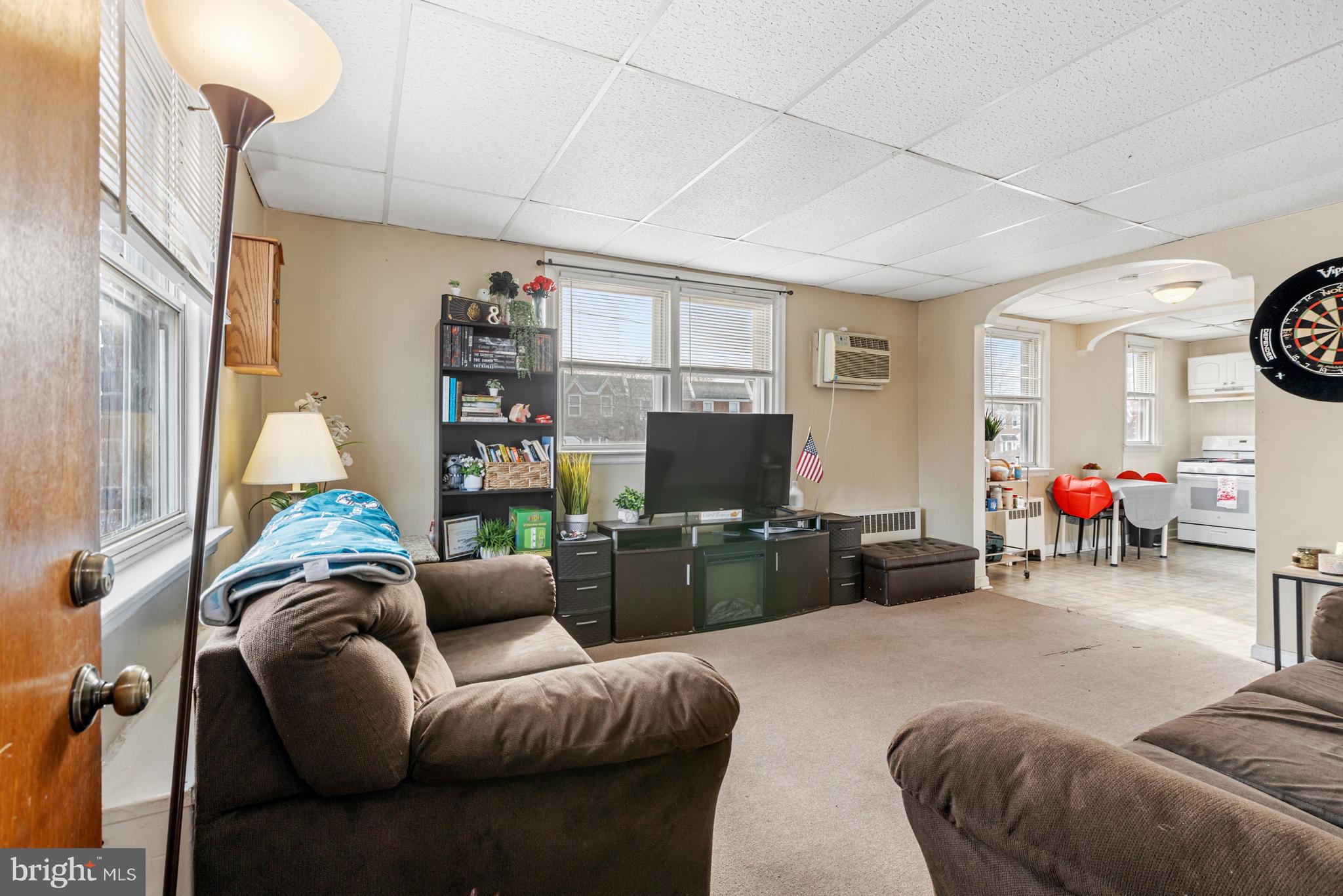 6136 Hawthorne Street Philadelphia, PA 19135 - Photo 7 of 38 a living room with furniture a window and a flat screen tv