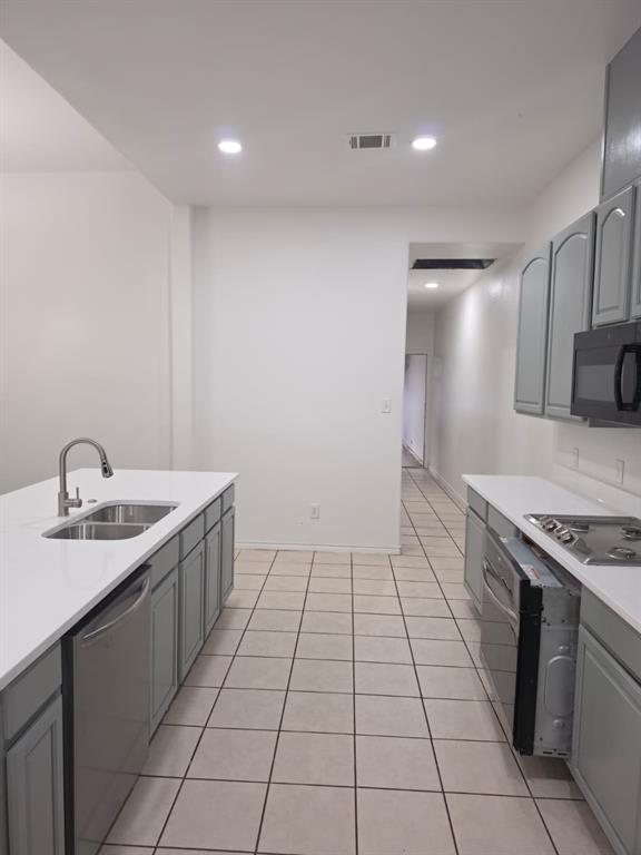8047 New Kent Road Frisco, TX 75035 - Photo 19 of 27 Modern kitchen featuring light gray cabinetry, white countertops, stainless steel sink with gooseneck faucet, tile flooring, and recessed lighting