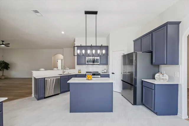 a kitchen with refrigerator and wooden cabinets