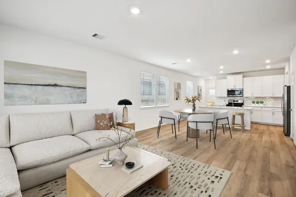 a living room with furniture and view of kitchen