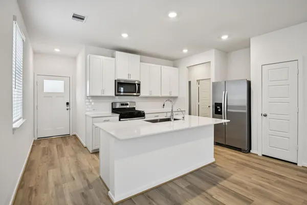 a kitchen with white cabinets and stainless steel appliances