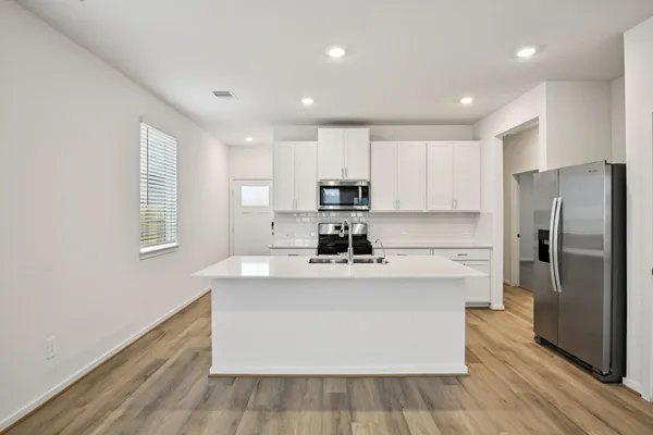 a kitchen with stainless steel appliances granite countertop a white stove top oven a refrigerator a sink and dishwasher