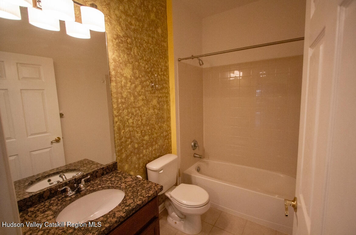 402 Commons Lane Saugerties, NY 12477 - Photo 20 of 29 a bathroom with a granite countertop sink toilet mirror and shower