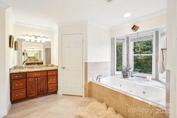 a large spacious bathroom with a tub sink shower and mirror