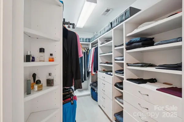 a view of walk in closet with clothes and shoes