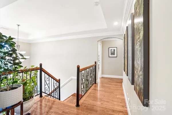 a view of a hallway with wooden floor and stairs