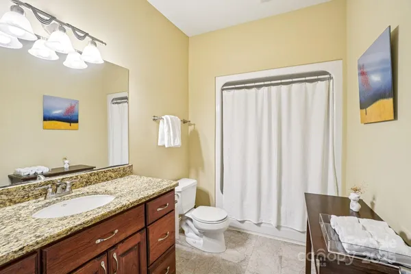 a bathroom with a granite countertop sink toilet and shower