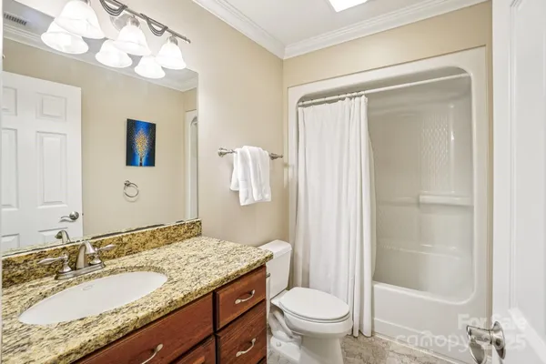 a bathroom with a granite countertop sink toilet and shower