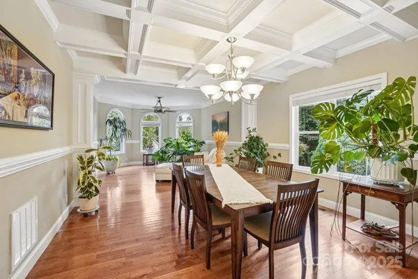 a view of a dining room with furniture a chandelier and wooden floor
