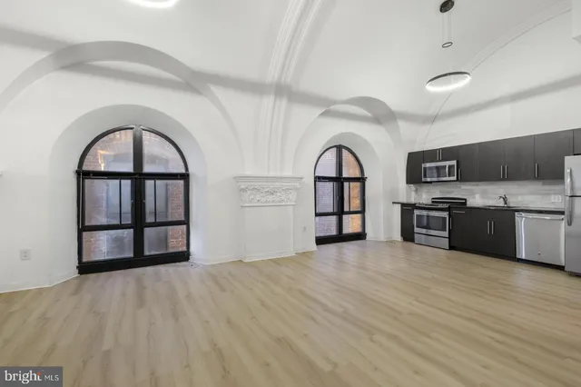 a view of empty room with a fireplace and wooden floor